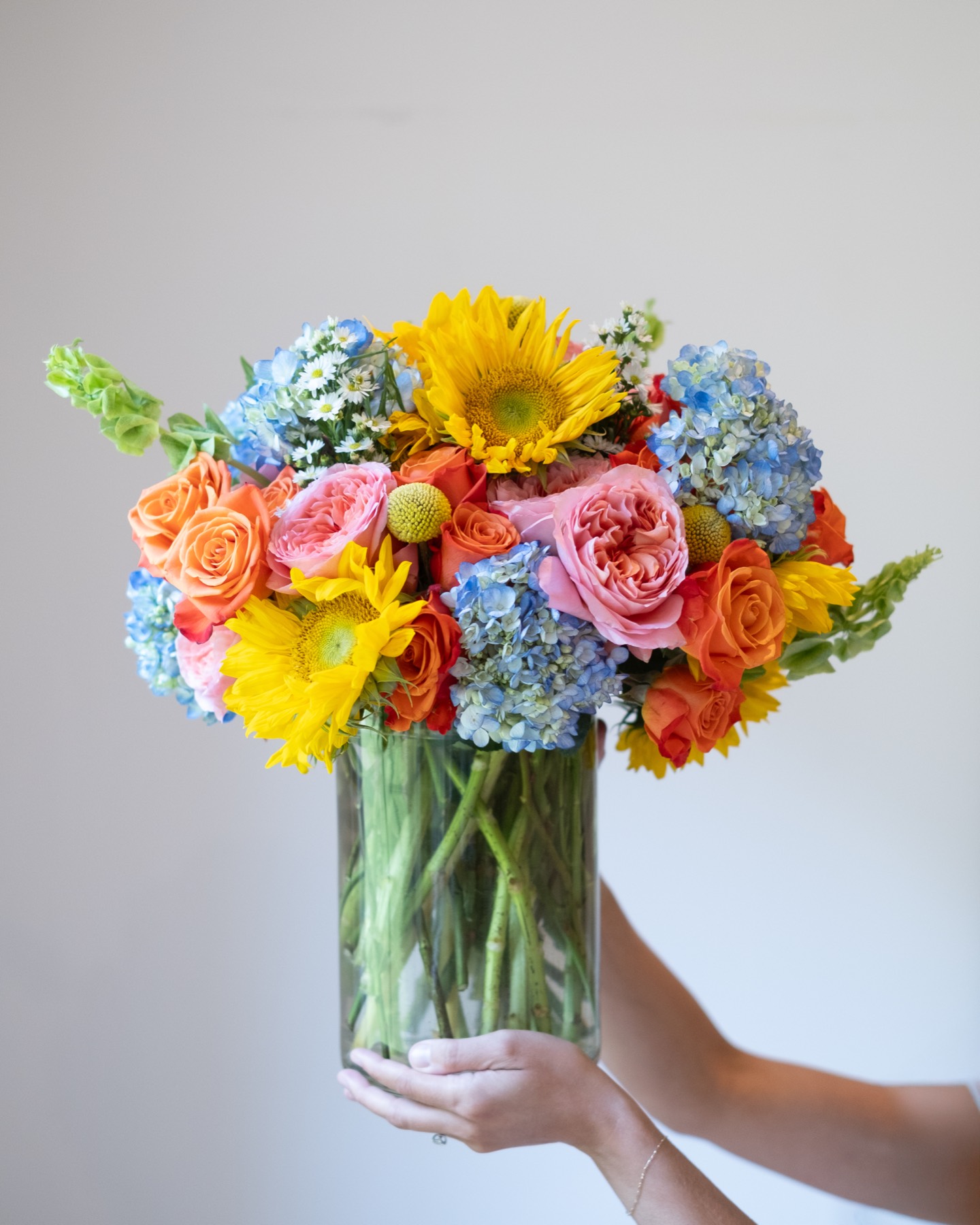 Colorful bouquet with blue hydrangea, yellow and orange blooms