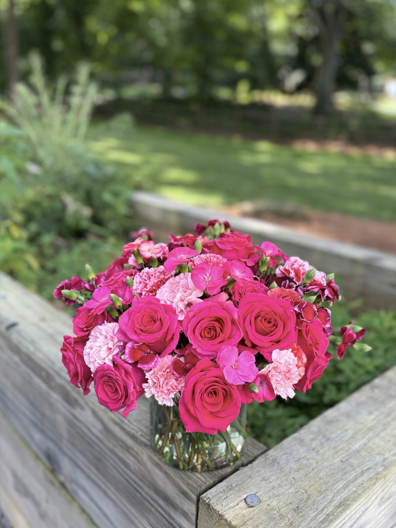 Hot pink roses and carnations bouquet in a glass vase